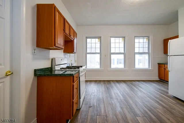 a kitchen with stainless steel appliances granite countertop wooden floors and sink
