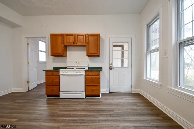 a view of kitchen with granite countertop cabinets and window