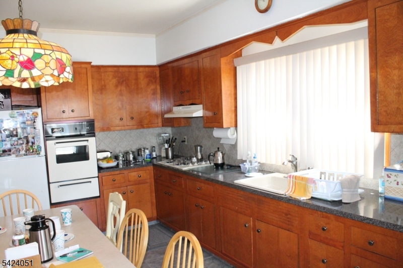 79 Nagle Street Paterson, NJ 07501 - Photo 3 of 7 a kitchen with stainless steel appliances granite countertop a sink a stove and a dining table view