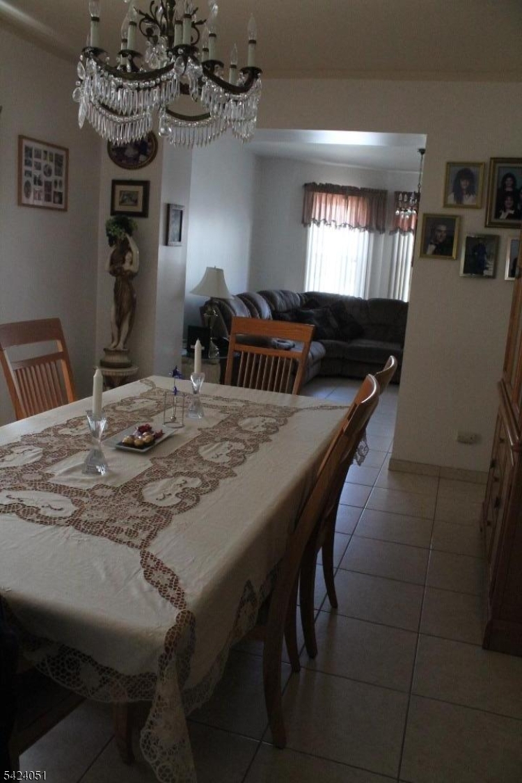 79 Nagle Street Paterson, NJ 07501 - Photo 5 of 7 a dining room with a table chairs and chandelier