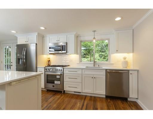 37 Tower Road Lexington, MA 02421 - Photo 6 of 20 a kitchen with kitchen island white cabinets a stove a sink and a refrigerator