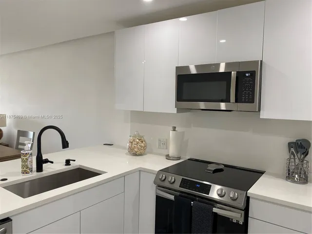 a kitchen with appliances a refrigerator and cabinets