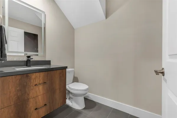 a bathroom with a toilet a sink and mirror