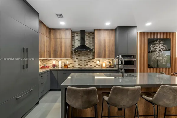 a kitchen with stainless steel appliances granite countertop a table chairs sink and cabinets