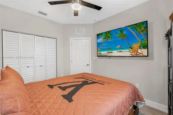 a bedroom with a bed and painting on the wall