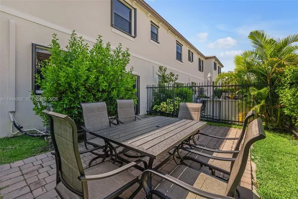 a view of a wooden bench with chairs in patio