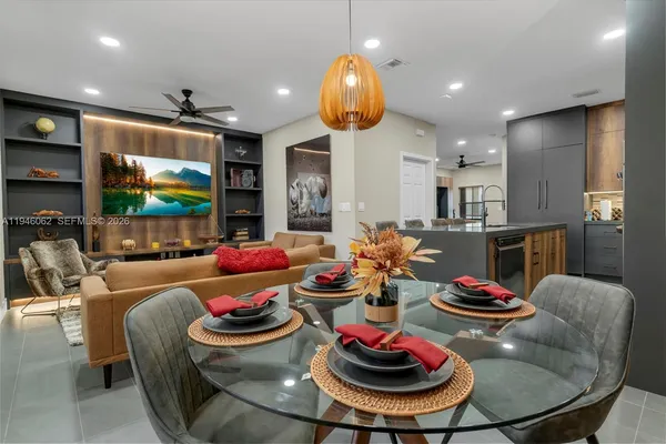 a living room with furniture kitchen and a chandelier