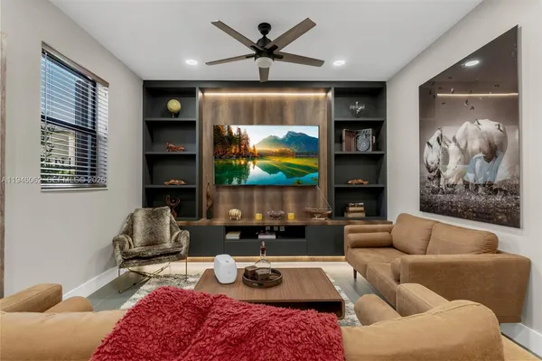 a living room with furniture a flat screen tv and a large window