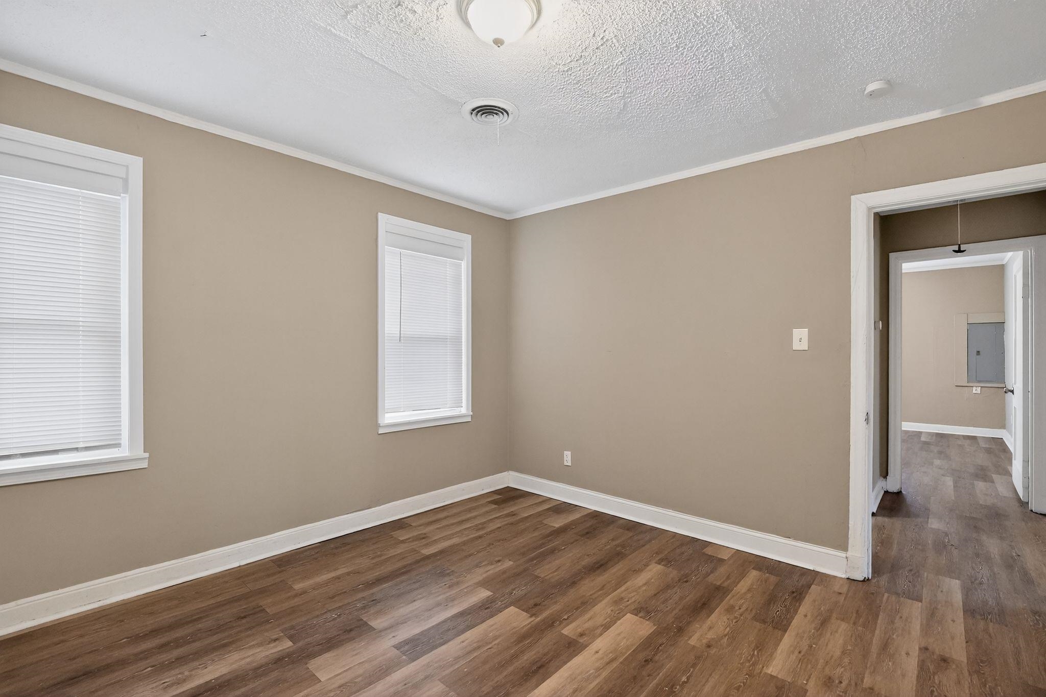 356 Hewlett Road Memphis, TN 38109 - Photo 16 of 30 Unfurnished room featuring a textured ceiling, dark wood-style flooring, and crown molding