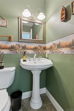 a bathroom with a toilet sink and mirror