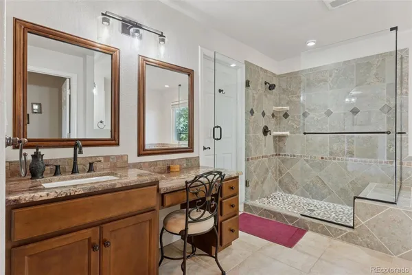 a bathroom with a granite countertop sink mirror and a shower