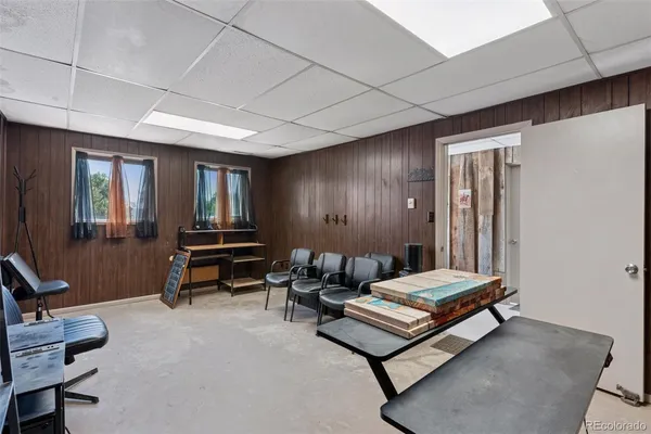 a living room with furniture a desk and chair with the wooden floor