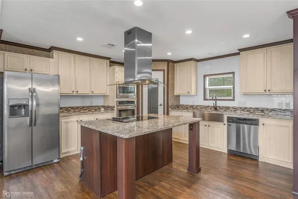 a kitchen with kitchen island a counter top space cabinets and stainless steel appliances