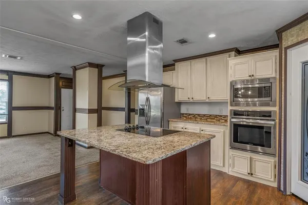 a kitchen with stainless steel appliances granite countertop counter space and wooden floor