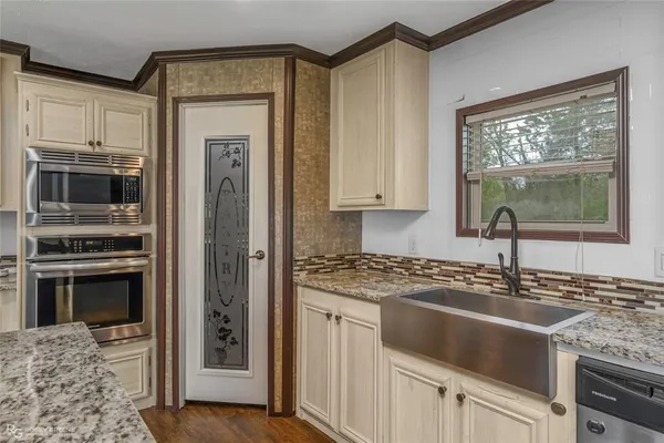 a kitchen with granite countertop a sink stainless steel appliances and cabinets
