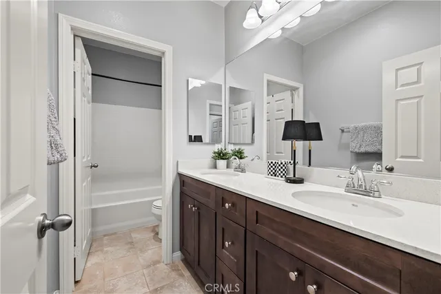 a spacious bathroom with a double vanity sink a mirror and a bathtub