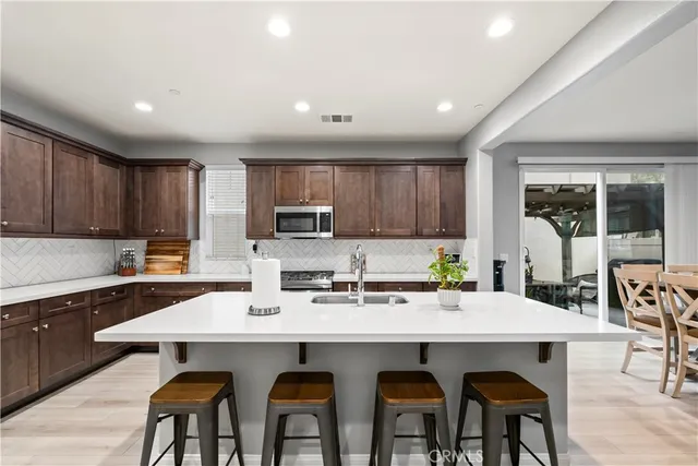 a kitchen with stainless steel appliances stove a sink and microwave
