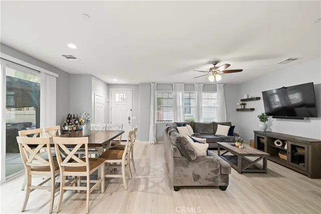 a dining room with furniture a flat screen tv and floor to ceiling window