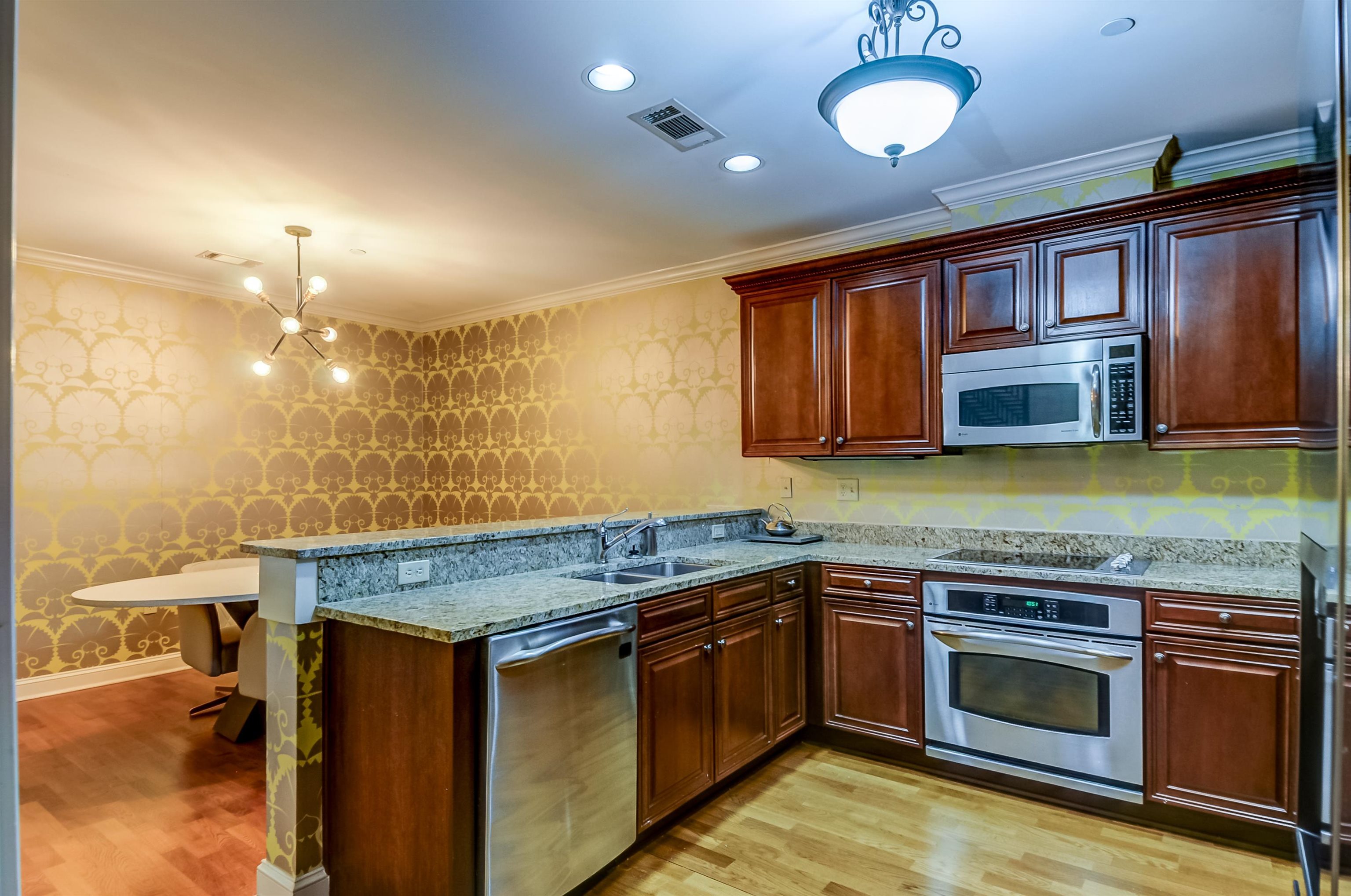 591 Lexington Road, Unit 303 Memphis, TN 38117 - Photo 17 of 34 a kitchen with stainless steel appliances granite countertop wooden cabinets stove top oven and sink