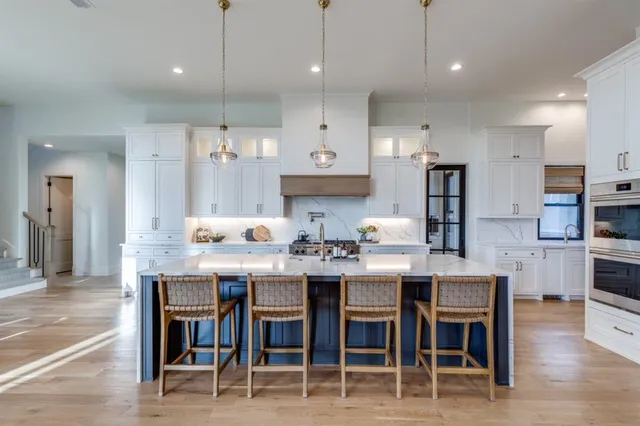 a kitchen with kitchen island a dining table chairs and wooden floor
