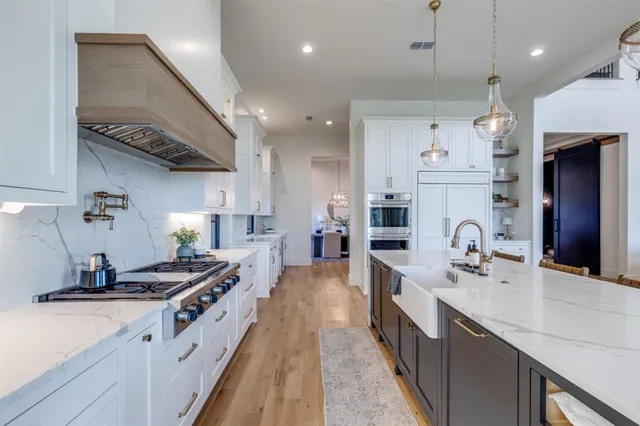 a large kitchen with stainless steel appliances lots of counter space and a sink