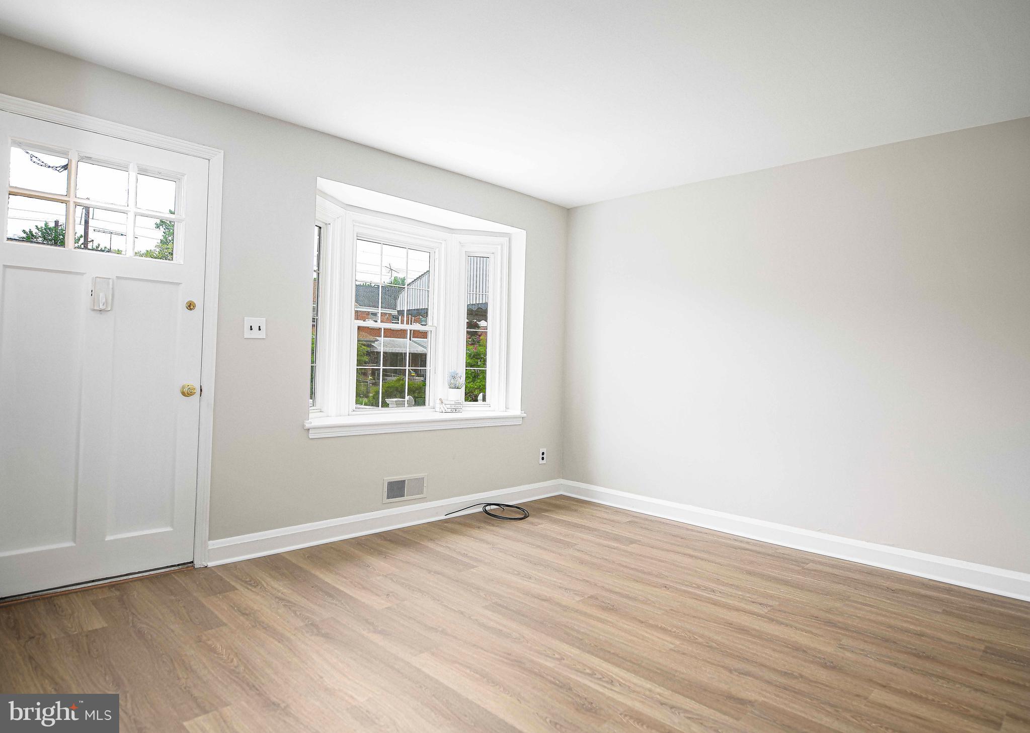 747 Middlesex Road Baltimore, MD 21221 - Photo 5 of 25 an empty room with wooden floor and windows
