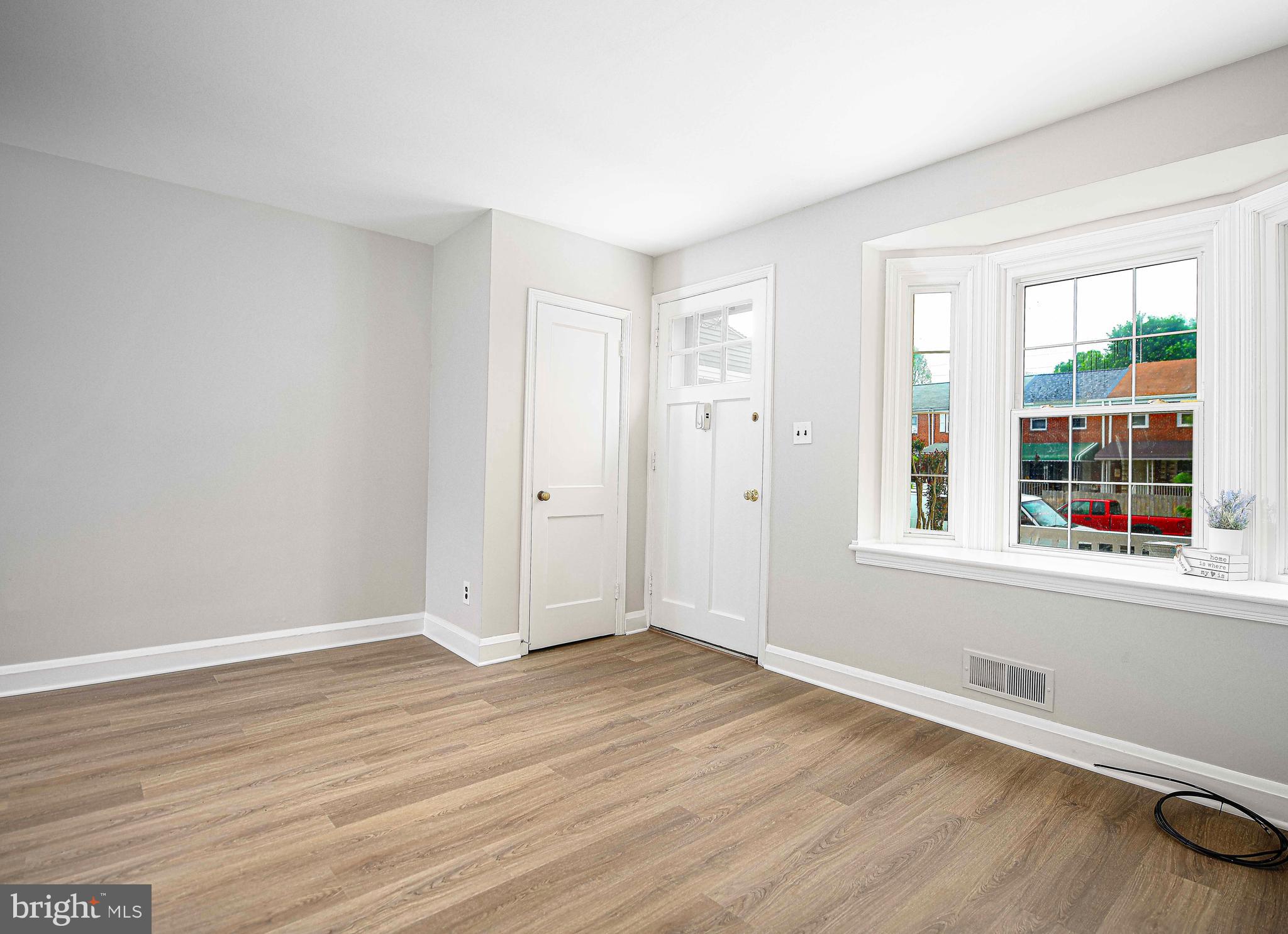 747 Middlesex Road Baltimore, MD 21221 - Photo 7 of 25 a view of an empty room with wooden floor and a window