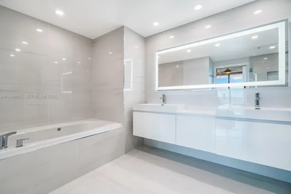 a bathroom with a bathtub sink mirror and toilet