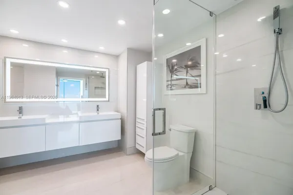 a bathroom with a double vanity sink toilet and shower