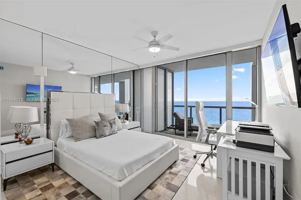 a bedroom with a bed a large window and couch
