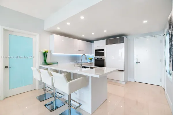 a view of kitchen with stainless steel appliances refrigerator stove microwave and cabinets