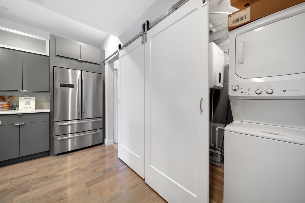 a view of a refrigerator in kitchen and an empty room