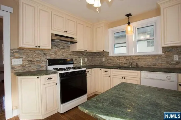 a kitchen with granite countertop cabinets stainless steel appliances and a sink