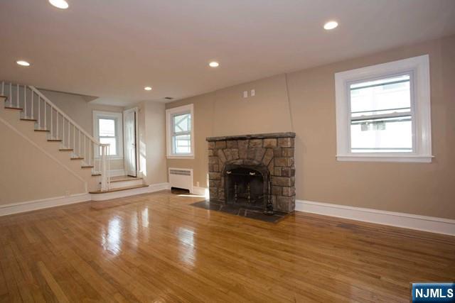 154 Sussex Road Tenafly, NJ 07670 - Photo 6 of 12 an empty room with wooden floor fireplace and windows