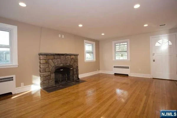 an empty room with windows and a fireplace