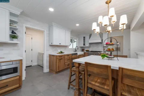 a kitchen that has a table chairs and a refrigerator