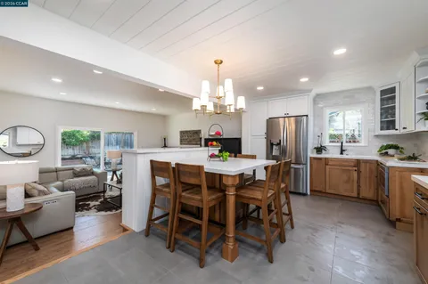a kitchen with a dining table chairs stainless steel appliances and cabinets