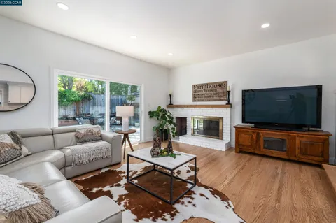 a living room with furniture a flat screen tv and a fireplace