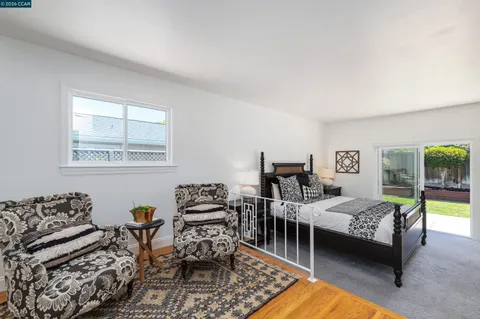 a bedroom with furniture and a large window