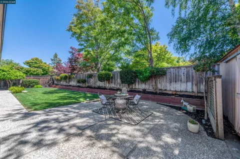 a view of a backyard with table and chairs and wooden fence