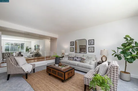 a living room with furniture potted plant and a large window