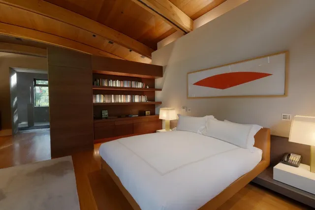 a bedroom with a bed and a large window