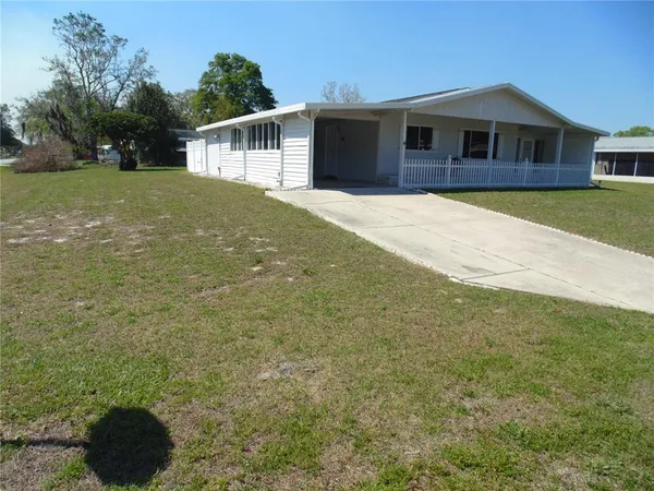 a front view of a house with yard and trees