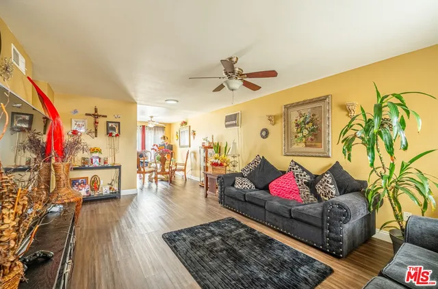 a living room with furniture a flat screen tv and a floor to ceiling window