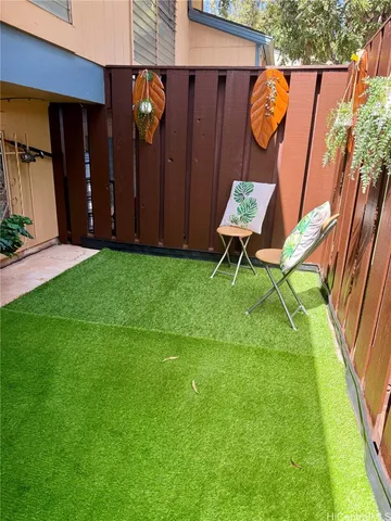 a backyard of a house with barbeque oven table and chairs