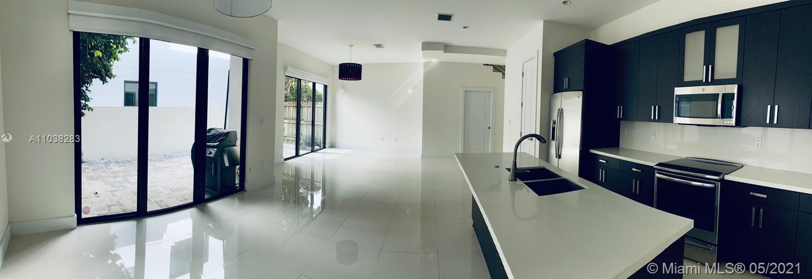 3318 Day Avenue, Unit 2 Miami, FL 33133 - Photo 6 of 29 a kitchen with stainless steel appliances granite countertop a refrigerator a stove and a refrigerator with wooden floor