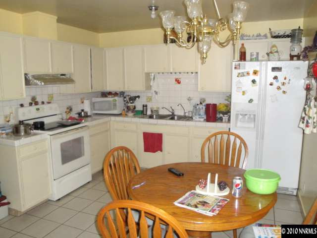3320 Kings Row Reno, NV 89503 - Photo 3 of 9 a kitchen with stainless steel appliances a dining table a microwave a refrigerator and dining table