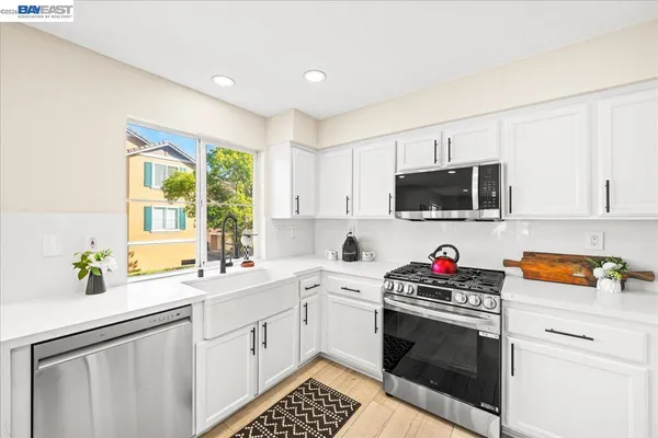 a kitchen with stainless steel appliances a stove a sink and a microwave