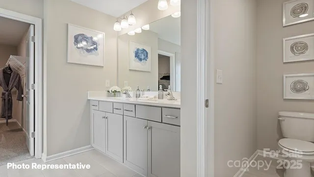 a bathroom with a granite countertop sink a toilet and a mirror