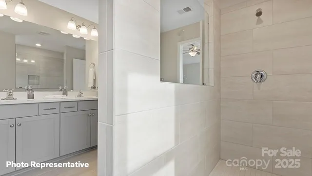 a bathroom with a double vanity sink a mirror and shower
